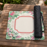 Coral tropical floral mahjong mat with hibiscus flowers, palm leaves, cream sections, and a scalloped edge.