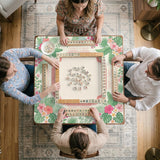 Coral tropical floral mahjong mat with hibiscus flowers, palm leaves, cream sections, and a scalloped edge.
