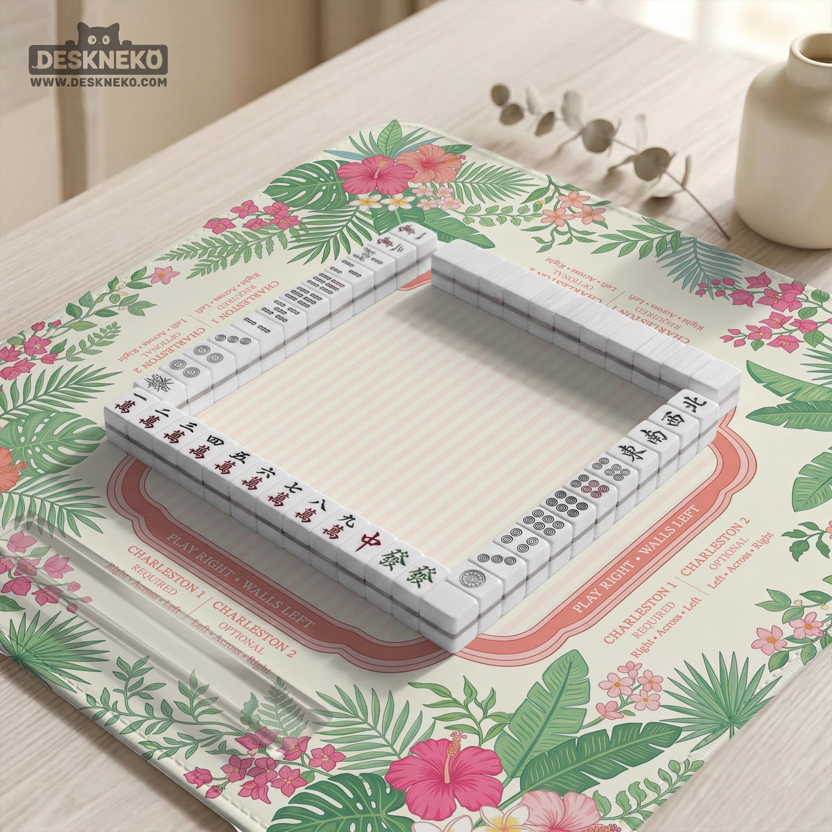 Coral tropical floral mahjong mat with hibiscus flowers, palm leaves, cream sections, and a scalloped edge.