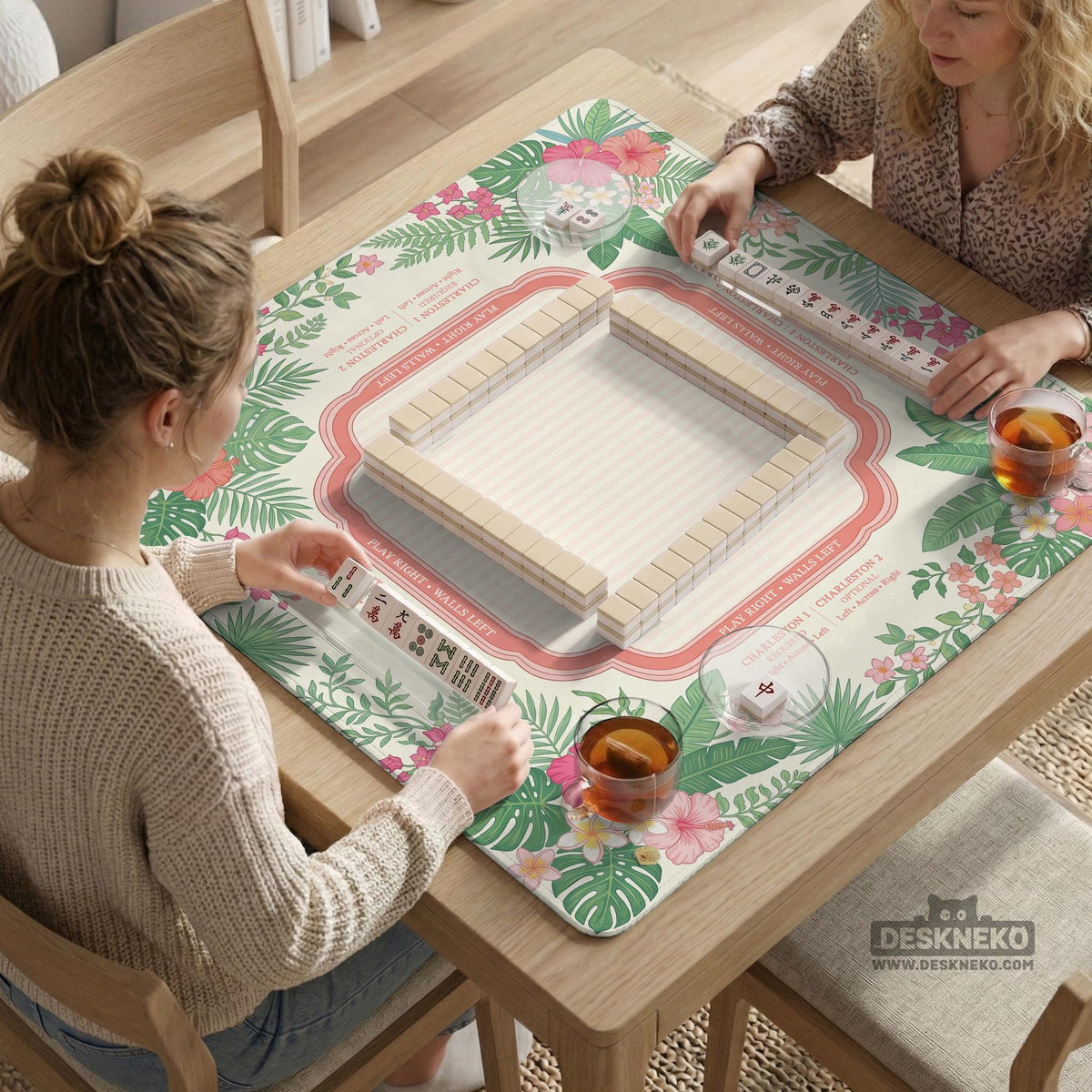 Coral tropical floral mahjong mat with hibiscus flowers, palm leaves, cream sections, and a scalloped edge.