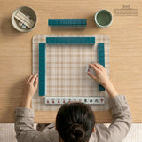 Beige plaid mahjong mat with a cream tartan pattern on a neutral background.