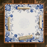Blue and white square mahjong mat with a hydrangea and bird botanical border and a plain center area.