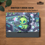 A Switch carrying case design with a cute green alien at a gaming desk, glowing cyan lights, and pastel stars on a dark background.