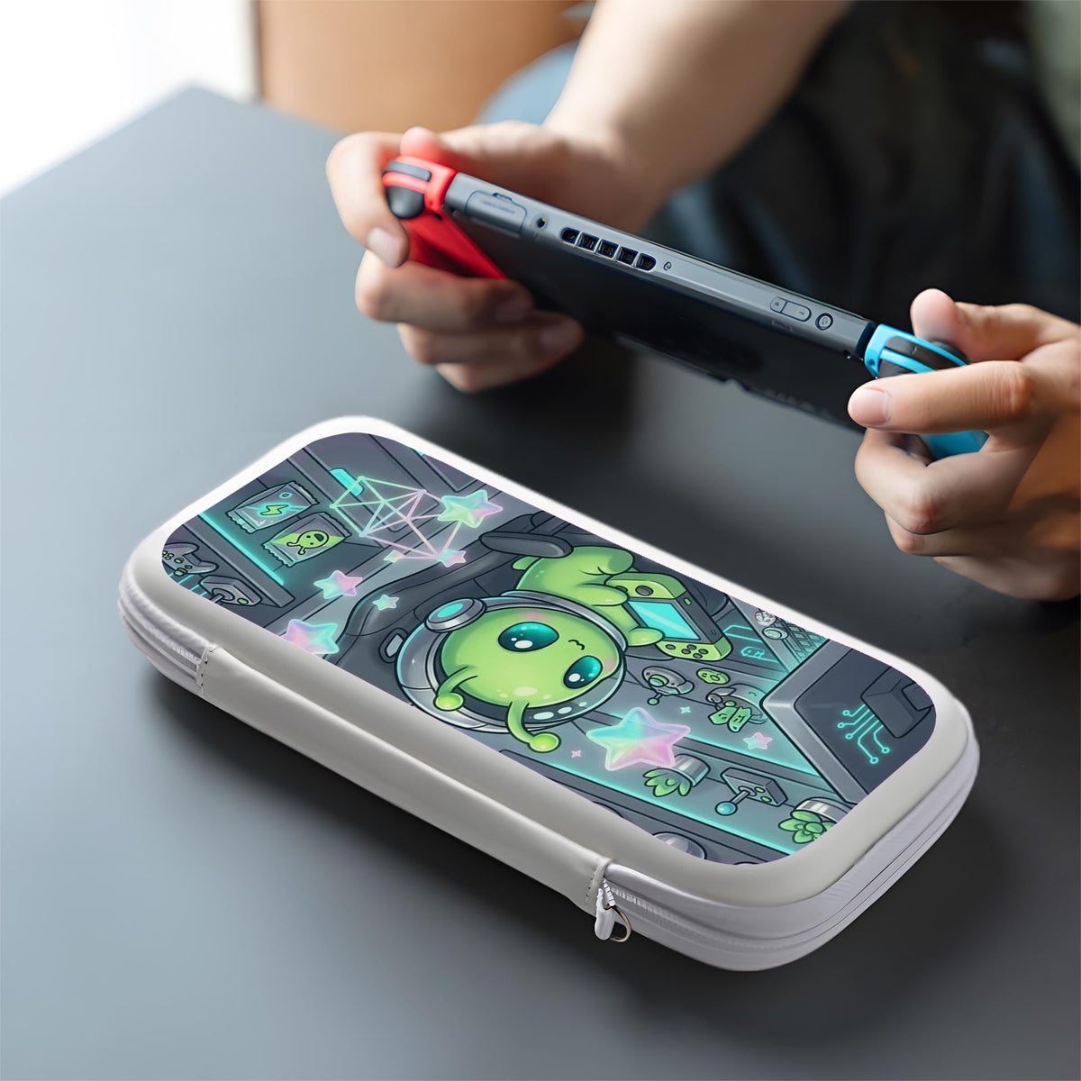A Switch carrying case design with a cute green alien at a gaming desk, glowing cyan lights, and pastel stars on a dark background.