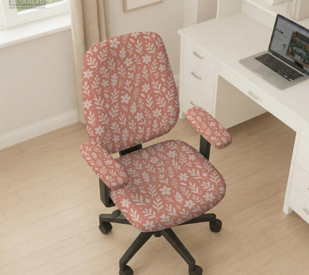 Pink chair cover with a botanical floral print shown on an office chair, with matching armrest covers and multiple cover style options.