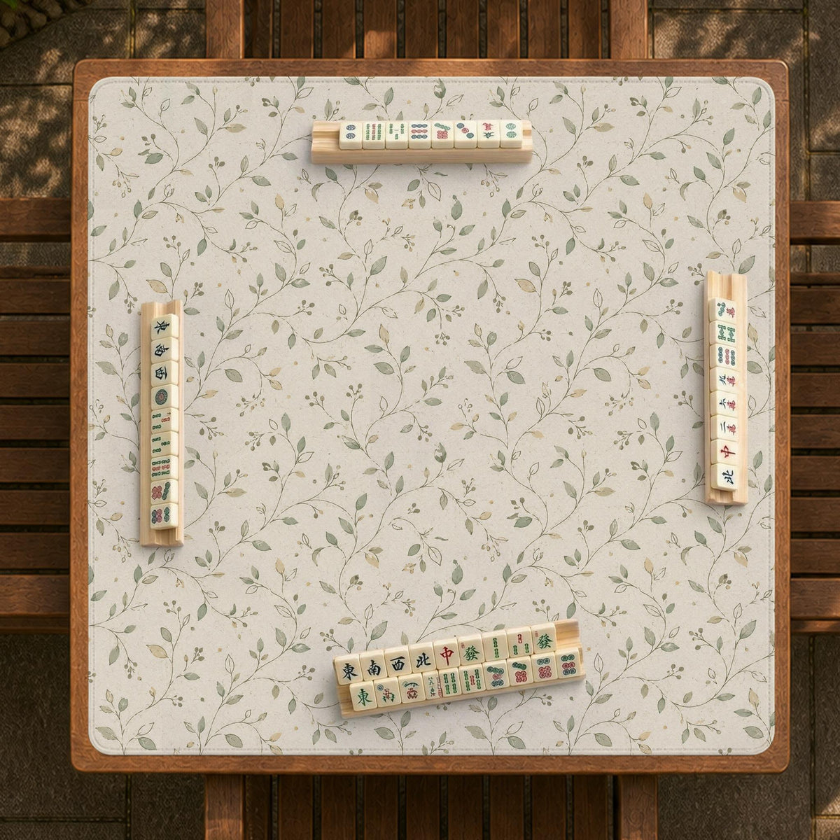 Sage green botanical mahjong mat with a cream background, trailing vines, and muted leaf designs.