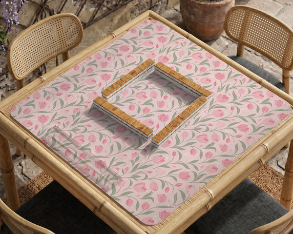 Pink mahjong mat with a tulip floral pattern in blush and sage tones and a scalloped edge.