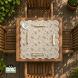 Neutral floral mahjong mat with delicate botanical line art and a scalloped edge on a cream background.