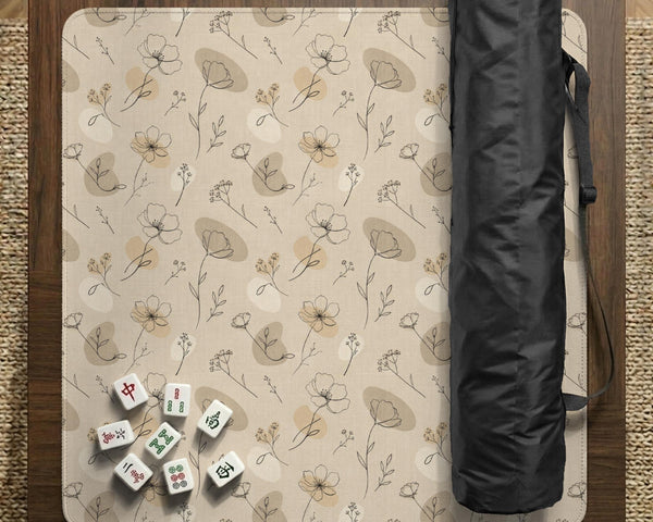 Neutral floral mahjong mat with delicate botanical line art and a scalloped edge on a cream background.