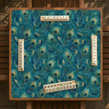 Teal mahjong mat with a peacock feather pattern in blue green tones.