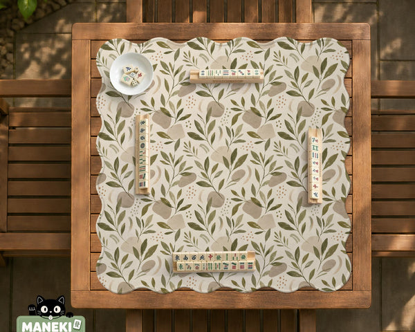 Green botanical mahjong mat with sage leaf and floral design and a scalloped edge.