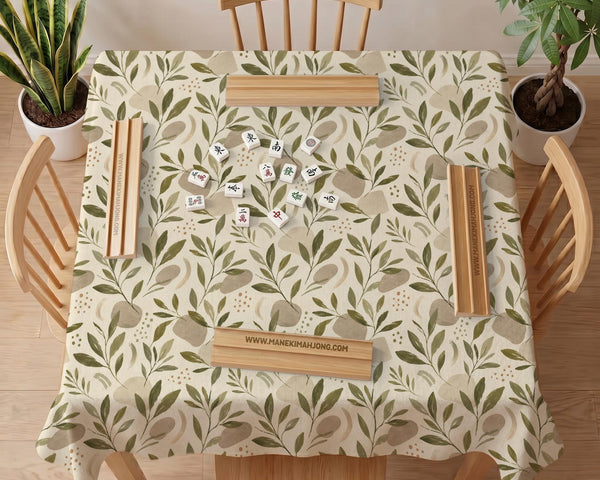 Green botanical mahjong mat with sage leaf and floral design and a scalloped edge.