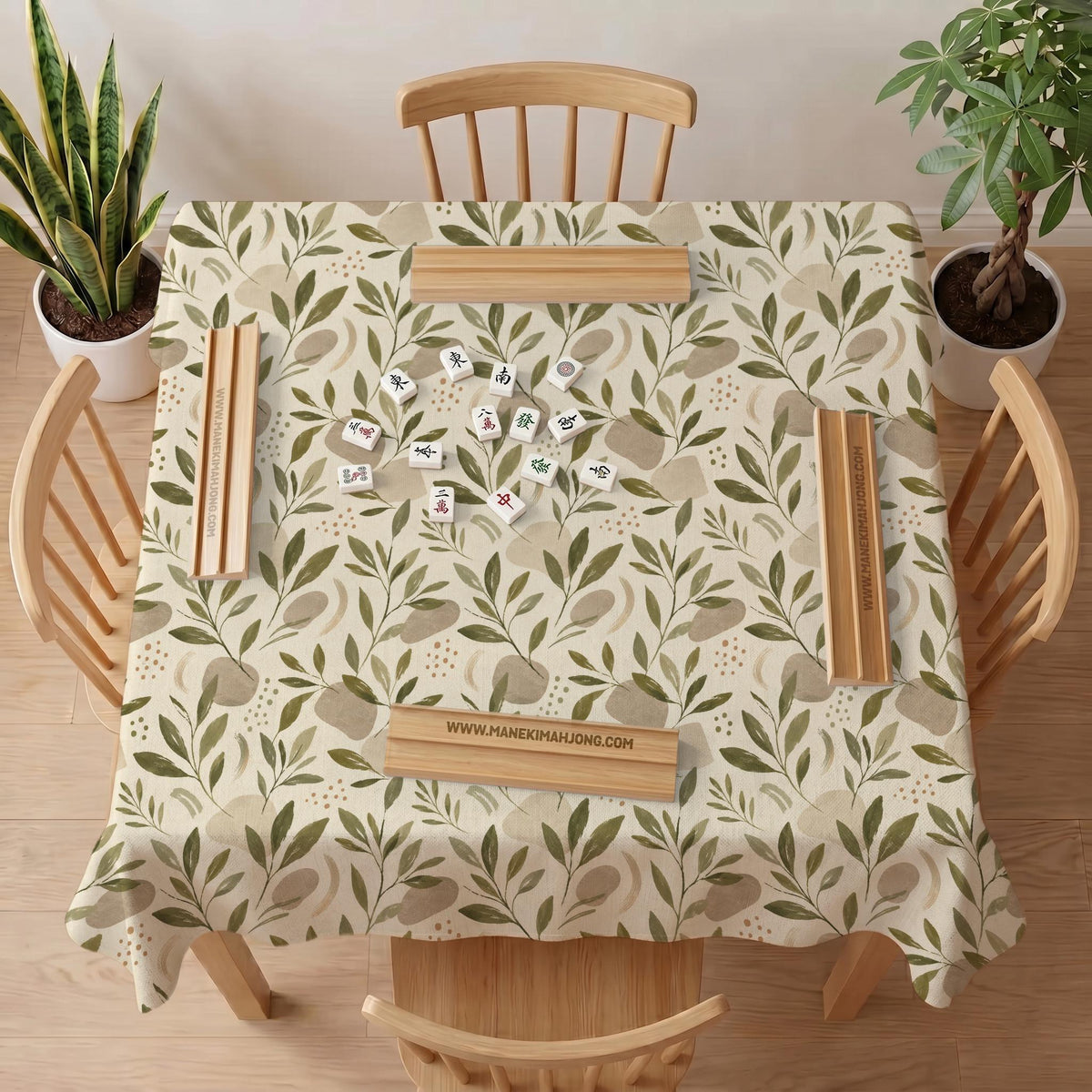 Green botanical mahjong mat with sage leaf and floral design and a scalloped edge.