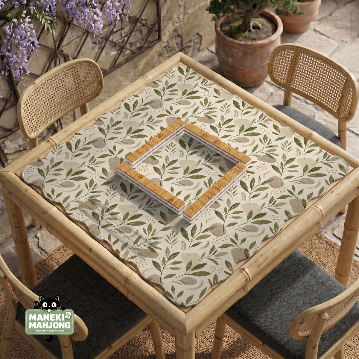 Green botanical mahjong mat with sage leaf and floral design and a scalloped edge.