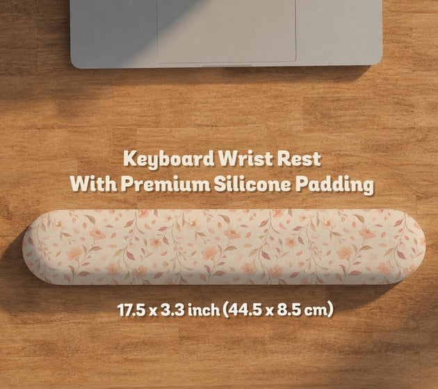 Blush pink floral mouse pad with wrist rest options, shown with peach blossoms, muted leaves, and a warm cream background.
