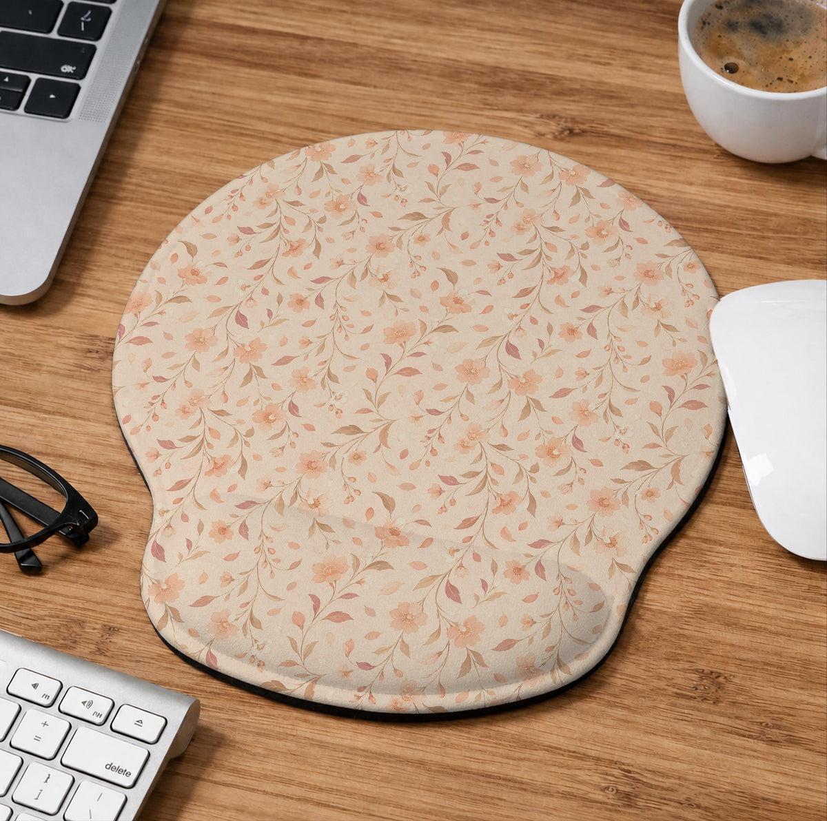 Blush pink floral mouse pad with wrist rest options, shown with peach blossoms, muted leaves, and a warm cream background.