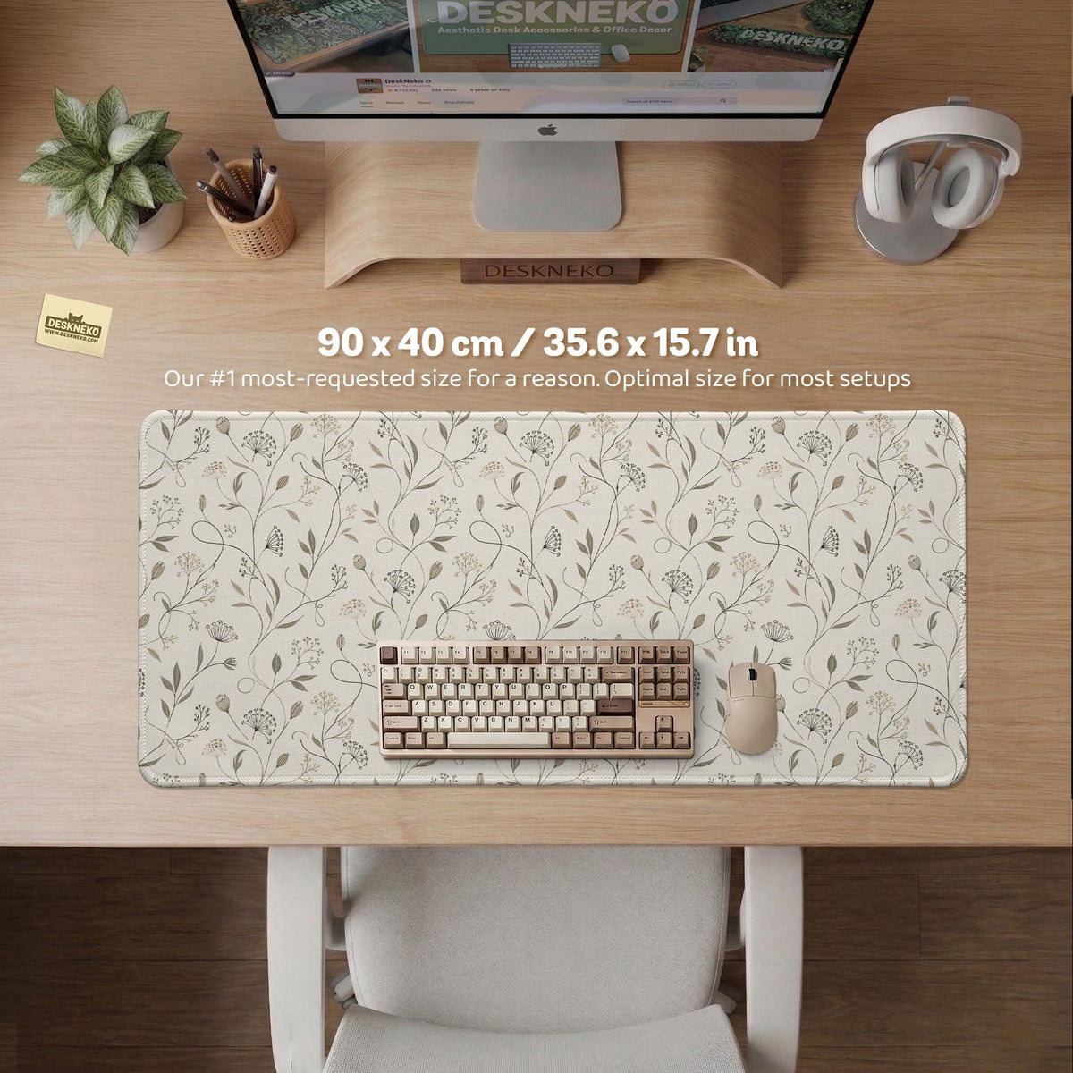Ivory desk mat with delicate sage and taupe vine and floral artwork on a neutral background.