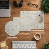 Ivory desk mat with delicate sage and taupe vine and floral artwork on a neutral background.