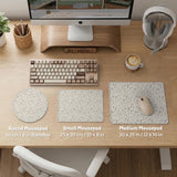 Ivory desk mat with delicate sage and taupe vine and floral artwork on a neutral background.