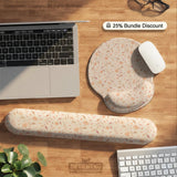 Blush pink floral mouse pad with wrist rest options, shown with peach blossoms, muted leaves, and a warm cream background.