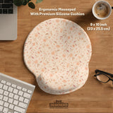 Blush pink floral mouse pad with wrist rest options, shown with peach blossoms, muted leaves, and a warm cream background.