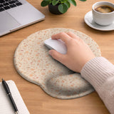 Blush pink floral mouse pad with wrist rest options, shown with peach blossoms, muted leaves, and a warm cream background.