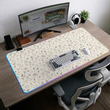 Ivory desk mat with delicate sage and taupe vine and floral artwork on a neutral background.