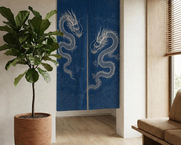 Indigo white dragon noren hung in a bright room doorway beside a potted plant and wooden bench.