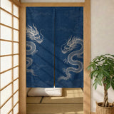Indigo noren curtain with two white dragons in a wooden doorway, split panels hanging over a tatami room.