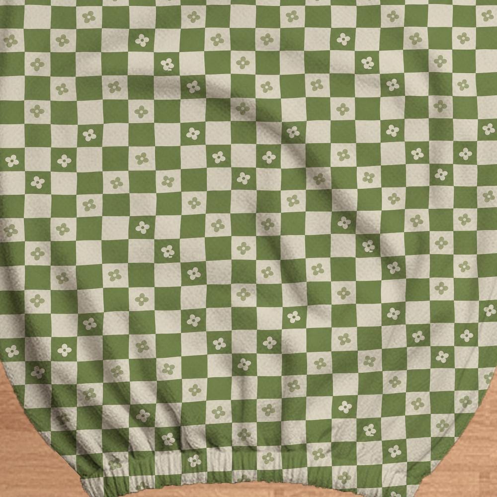 Gaming chair cover with a green and ivory checker pattern and small four-petal flowers.