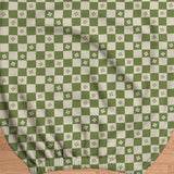Gaming chair cover with a green and ivory checker pattern and small four-petal flowers.