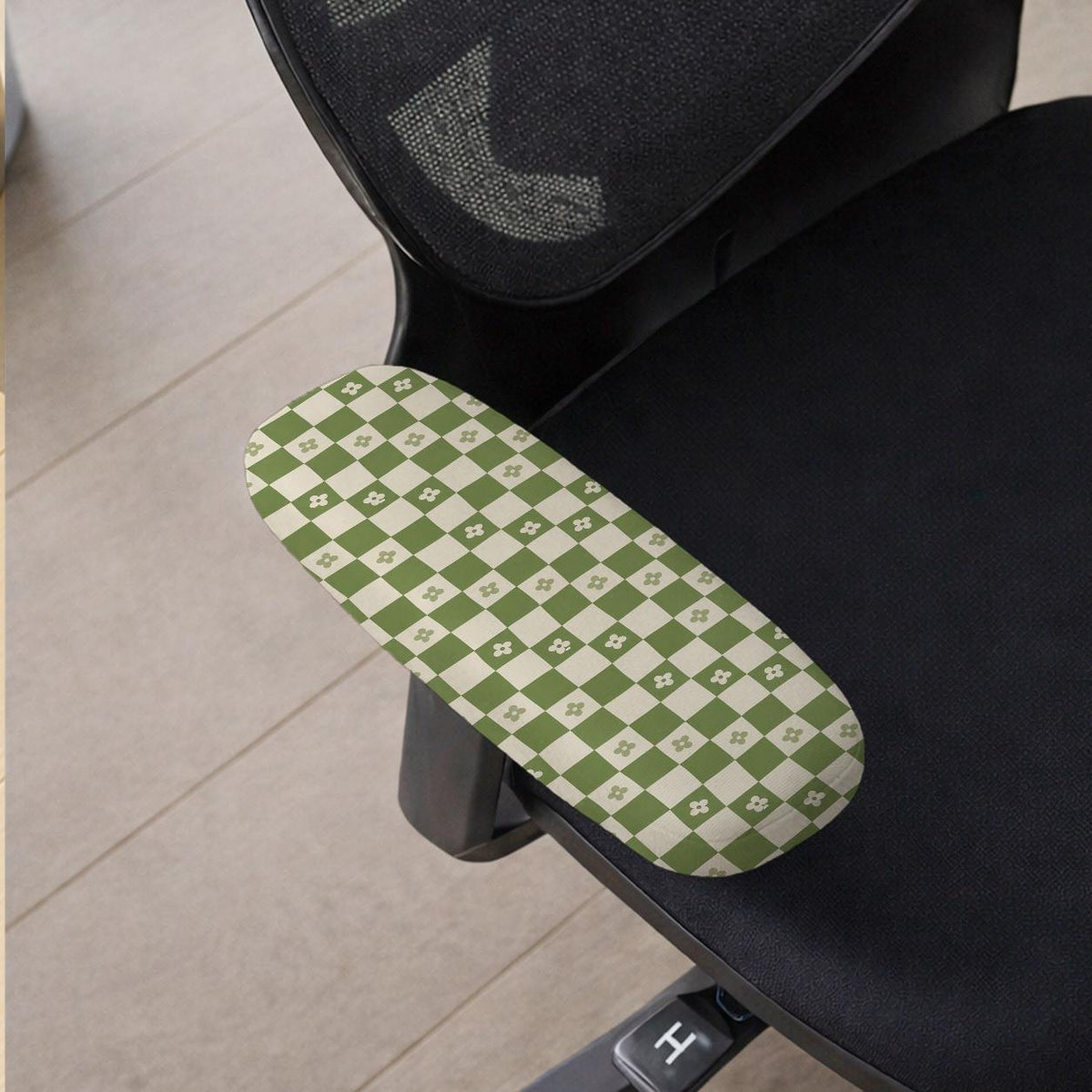 Gaming chair cover with a green and ivory checker pattern and small four-petal flowers.