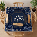 Navy mahjong mat with cranes, garden birds, pagodas, and blue and cream floral designs around a framed playing area with a printed Charleston guide.