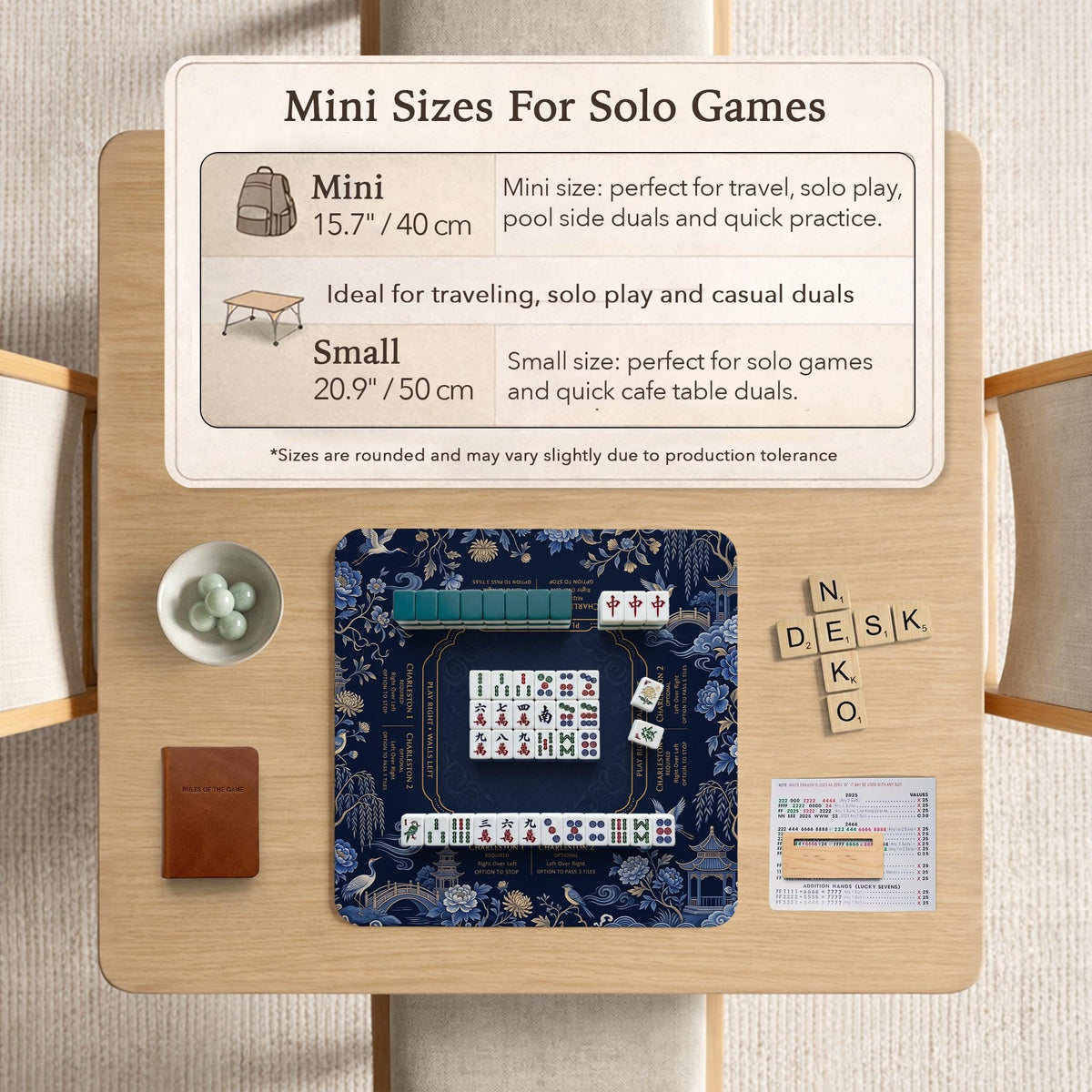 Navy mahjong mat with cranes, garden birds, pagodas, and blue and cream floral designs around a framed playing area with a printed Charleston guide.