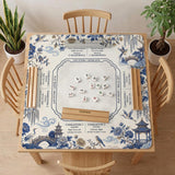 Square ivory mahjong mat with blue cranes, pagodas, flowers, and a blue border around the playing area.