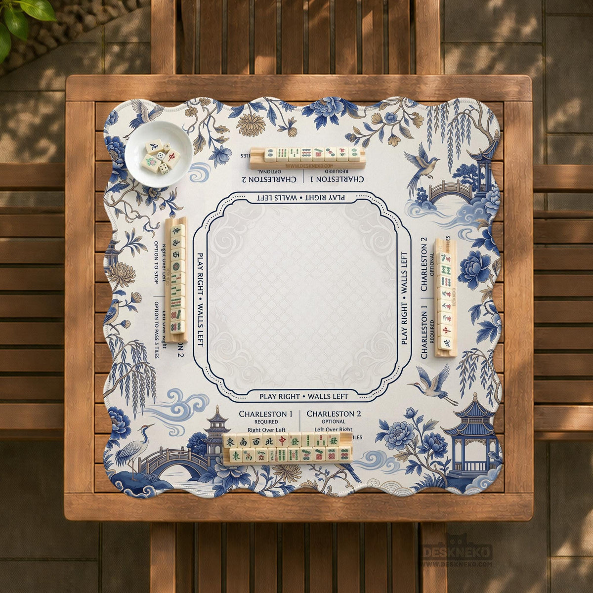 Square ivory mahjong mat with blue cranes, pagodas, flowers, and a blue border around the playing area.