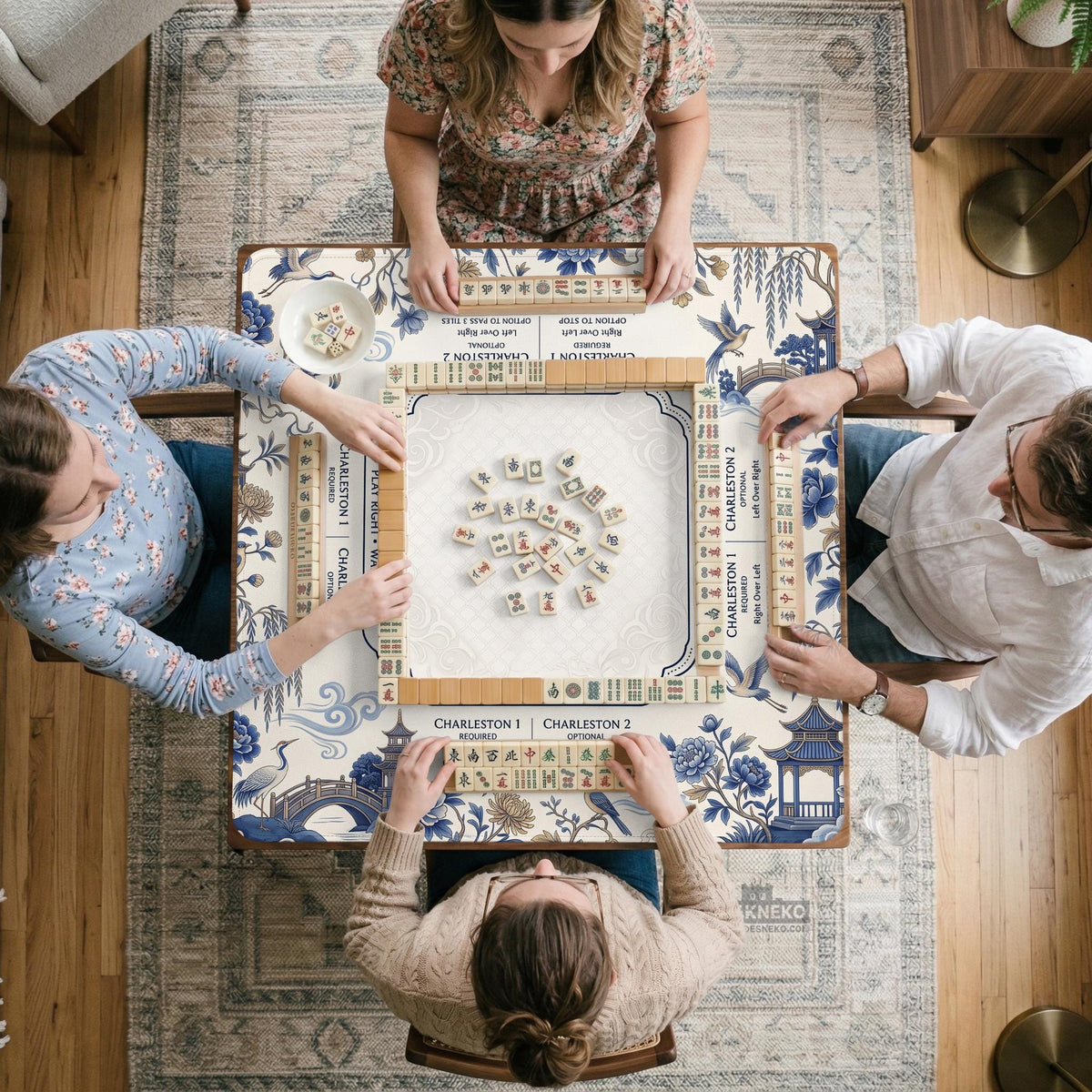 Square ivory mahjong mat with blue cranes, pagodas, flowers, and a blue border around the playing area.