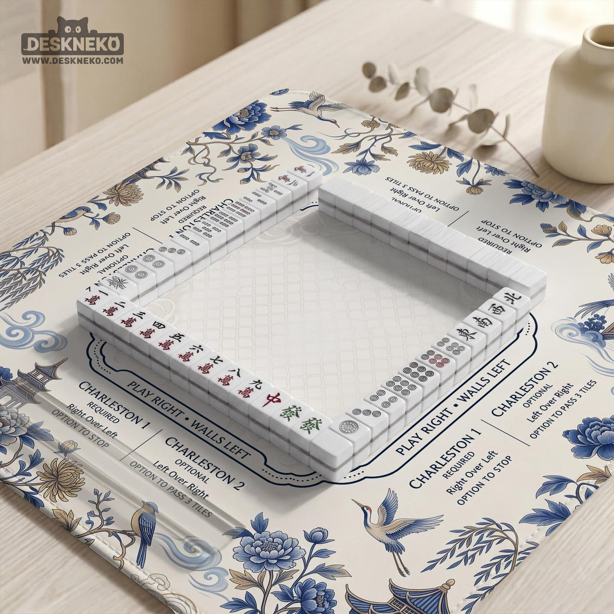 Square ivory mahjong mat with blue cranes, pagodas, flowers, and a blue border around the playing area.