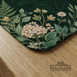 Square mahjong mat with a forest green botanical design, fern leaves, small cream flowers, and a printed Charleston guide around the center area.