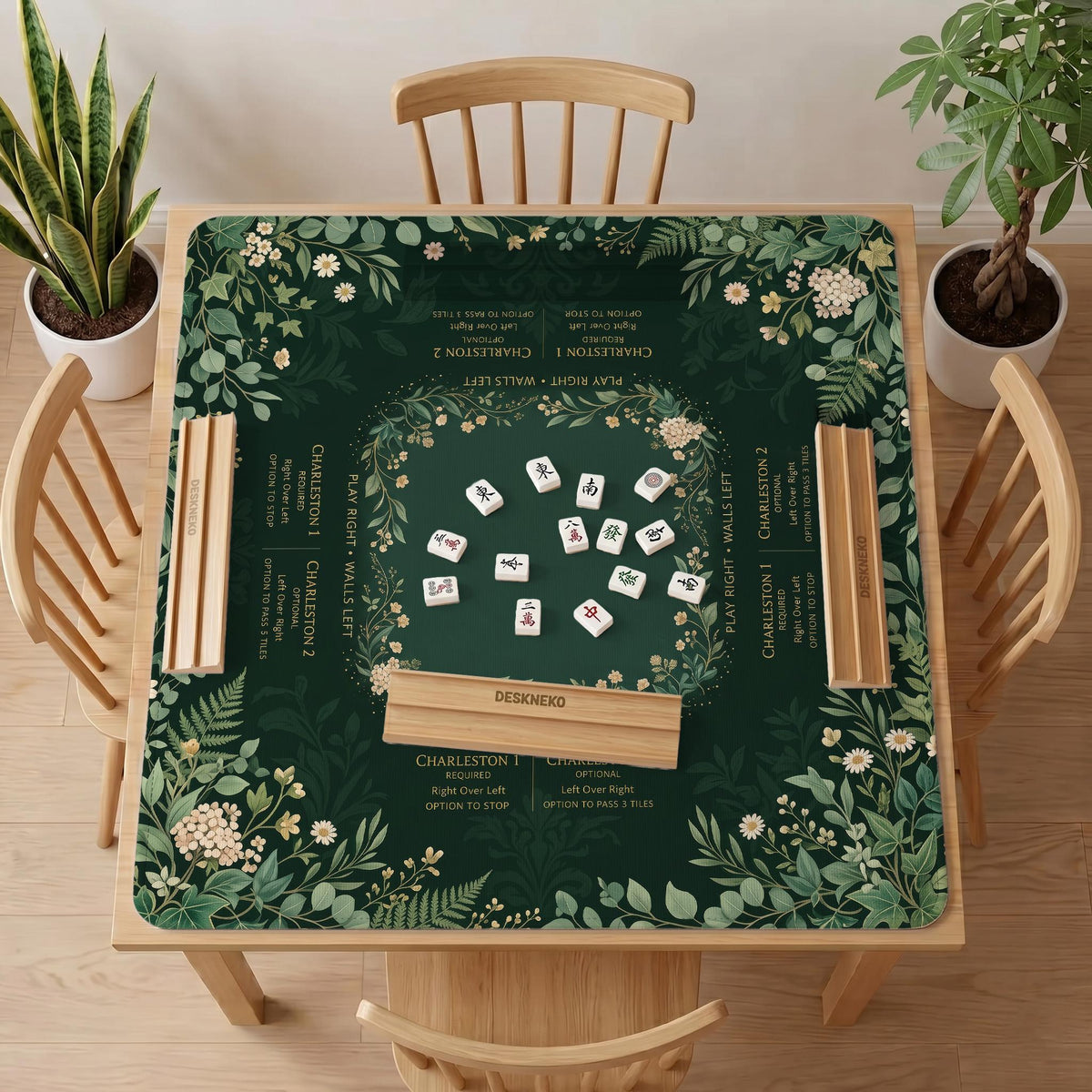 Square mahjong mat with a forest green botanical design, fern leaves, small cream flowers, and a printed Charleston guide around the center area.
