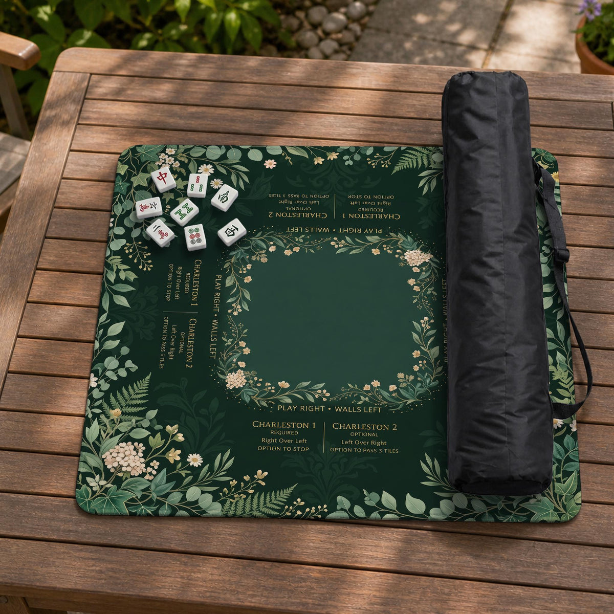Square mahjong mat with a forest green botanical design, fern leaves, small cream flowers, and a printed Charleston guide around the center area.