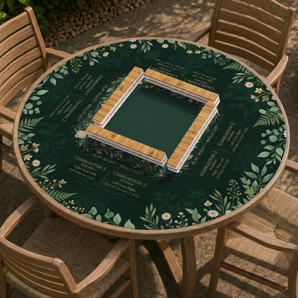 Square mahjong mat with a forest green botanical design, fern leaves, small cream flowers, and a printed Charleston guide around the center area.