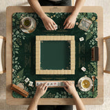 Square mahjong mat with a forest green botanical design, fern leaves, small cream flowers, and a printed Charleston guide around the center area.