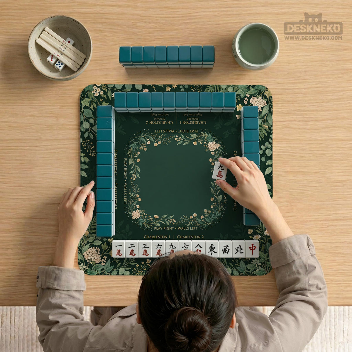 Square mahjong mat with a forest green botanical design, fern leaves, small cream flowers, and a printed Charleston guide around the center area.