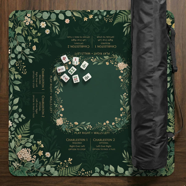 Square mahjong mat with a forest green botanical design, fern leaves, small cream flowers, and a printed Charleston guide around the center area.