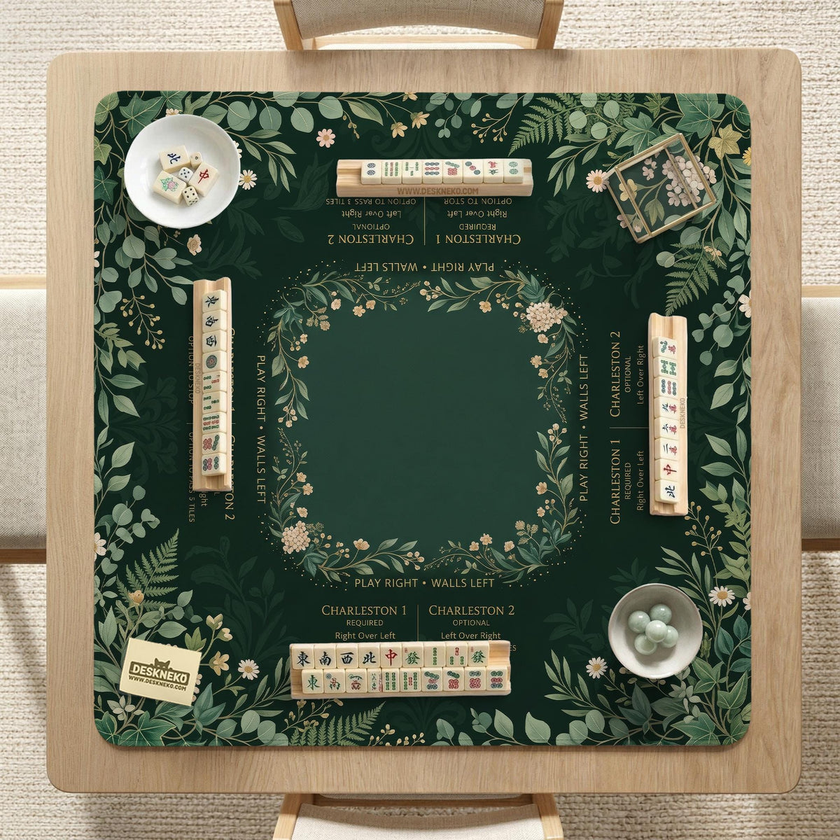 Square mahjong mat with a forest green botanical design, fern leaves, small cream flowers, and a printed Charleston guide around the center area.