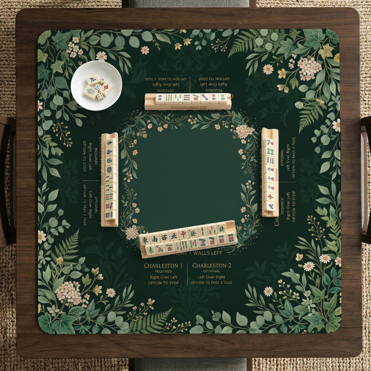 Square mahjong mat with a forest green botanical design, fern leaves, small cream flowers, and a printed Charleston guide around the center area.