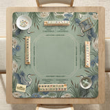American mahjong mat with a sage-green pond scene, blue-grey herons, water lilies, reeds, and printed play-direction reminders around the edge.