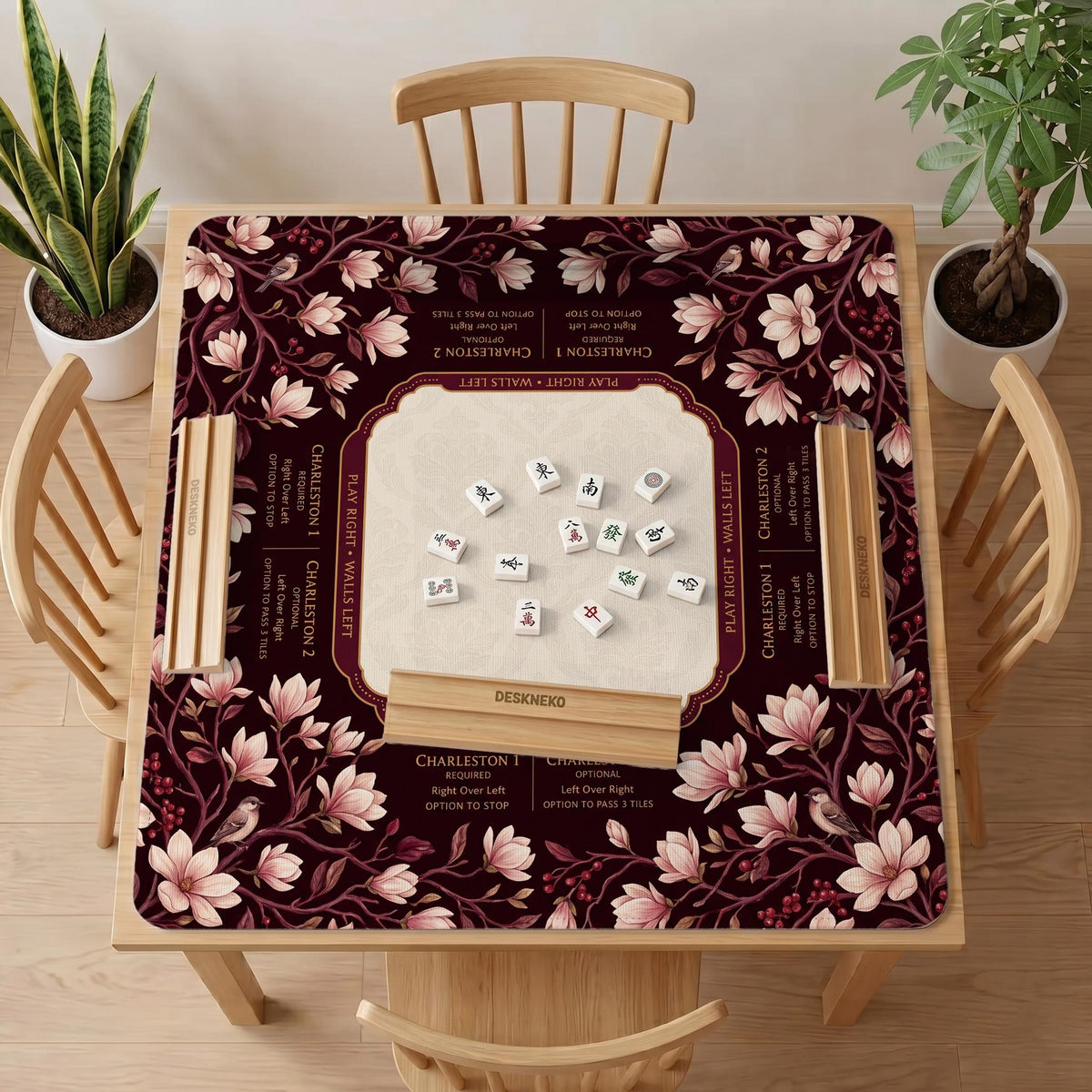 Cream American mahjong mat with a burgundy border of pale pink magnolia blossoms and printed play-direction and passing reminders.