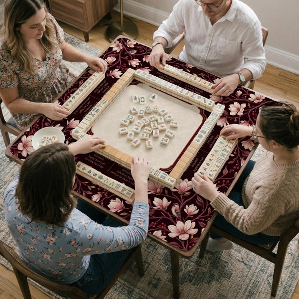 Cream American mahjong mat with a burgundy border of pale pink magnolia blossoms and printed play-direction and passing reminders.